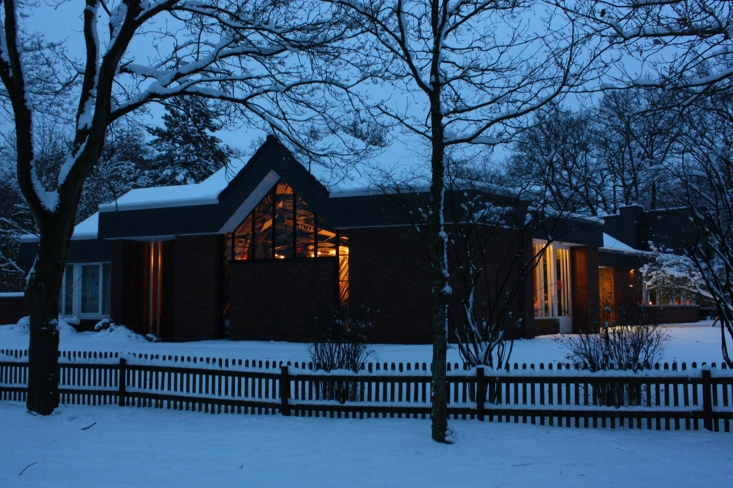 St. Johannes Haus im Schnee mit erleuchteten Fenstern