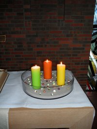 Glasschale mit je einer roten, grünen  und gelben Keerze auf dem Altar im St. Johannes Haus 