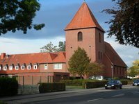 Backsteinkirche St. Christophorus am Brendelweg in Delmenhorst, wuchtiger Bau vor blauem Himmel, Autos auf der Straße