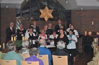 Chorsängerinnen und Sänder unter leuchtendem Stern im Kirchraum des St. Johannes Hauses in Hasport-Annenheide im Dezember 2011