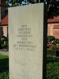 Gedenkstein der Gefallenen und Vermissten des zweiten Weltkriegs im Hintergrund die Mauern der Laurentius Kirche Hasbergen