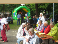 Hüpfburg, Tisch mit Gästen auf der Wiese vor dem Johannes Haus Hasport