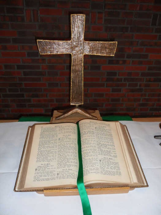 Das Altarkreuz der St. Johannesgemeinde mit der aufgeschlagenen Altarbibel. 