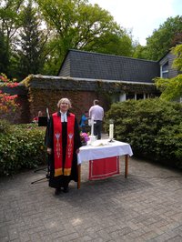 Pfarrerin Ulrike Klank im schwarzen Talar mit roter Stola anlässlich des Kirchweihfestes 2021 am Pfingstmontag auf dem Kirchhof von St. Johannes