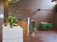 Kirchraum in St. Johannes mit Altar, Pult und Tisch mit jeweils einem Angebot zur Beschäftigung, Blumenschmuck