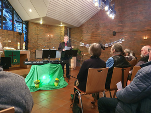 Kirchenmusiker Holger Jablonowski am Pult im Chorraum vor dem Altar von St. Johannes am 11.02.2023 im Vordergrund das Ehepaar Klank von hinten und Gäste