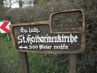 Aus Eichenholz geschnitzter Wegweiser mit dem Abbild der St. Katharinenkirche und dem Schriftzug: Ev. luth. St. Katharinenkirche 300 Meter rechts 