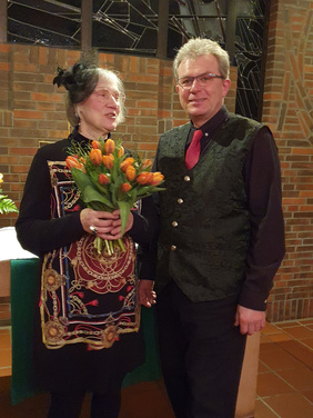 Pfarrerin Ulrike Klank mit dem Tulpenstrauß, daneben Holger Jablonowski 11.2.2023