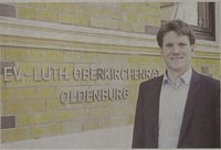 Dr. David Kleinhans vor dem Schriftzug Ev.-Luth.Oberkirchenrat Oldenburg